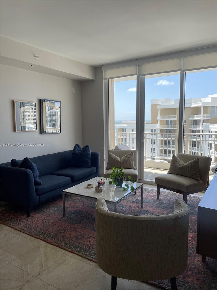 801 Brickell Key Boulevard, Unit 2705 Miami, FL 33131 - Photo 4 of 14 a living room with furniture and a large window
