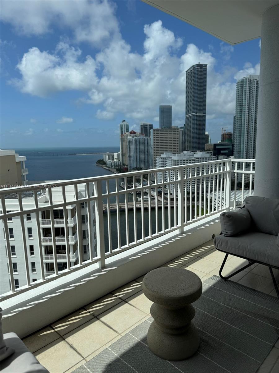 801 Brickell Key Boulevard, Unit 2705 Miami, FL 33131 - Photo 8 of 14 a view of a balcony with chair and wooden floor
