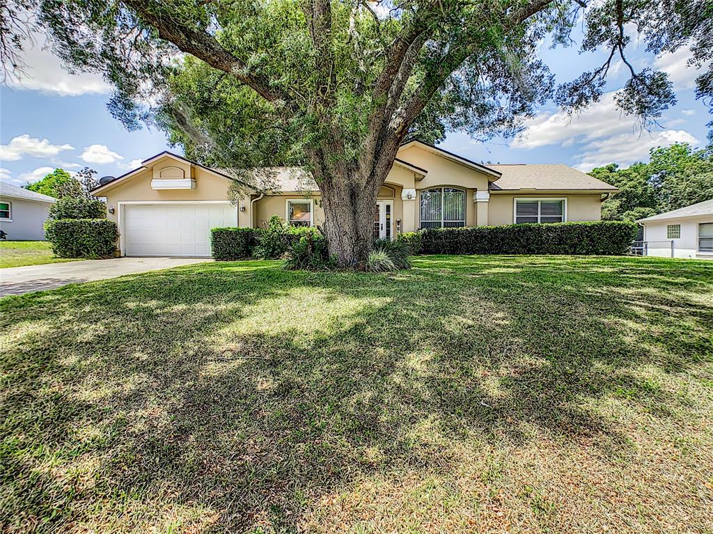 6000 Southwest 112th Pl Road Ocala, FL 34476 - Photo 1 of 1 a front view of a house with a yard and trees