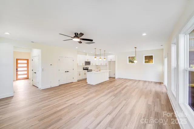 a view of a livingroom with wooden floor and a ceiling fan
