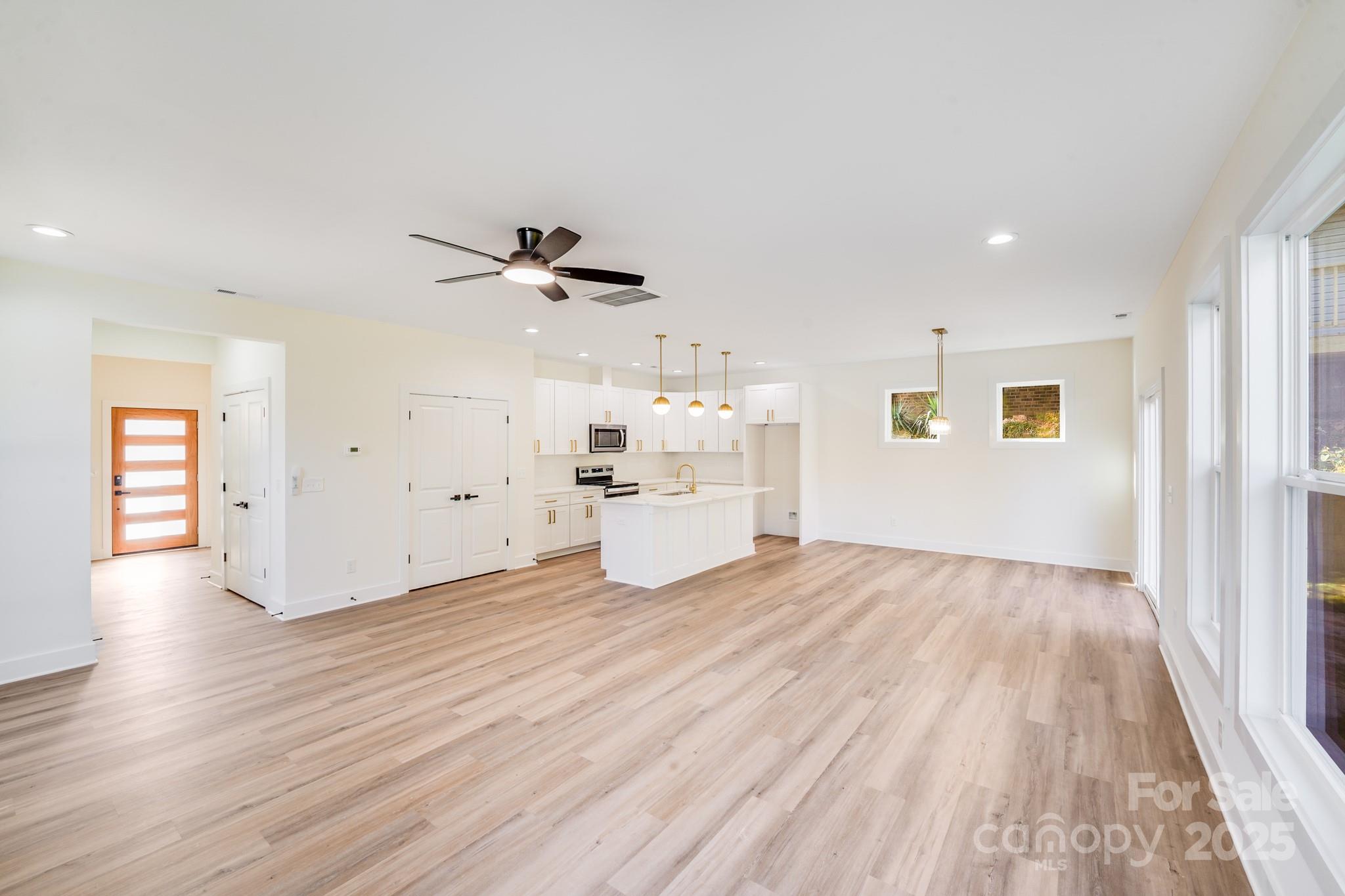 4538 Orphanage Road Concord, NC 28027 - Photo 4 of 14 a view of a livingroom with wooden floor and a ceiling fan