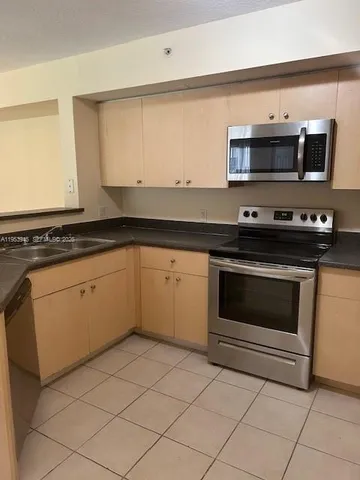 a kitchen with granite countertop white cabinets and appliances