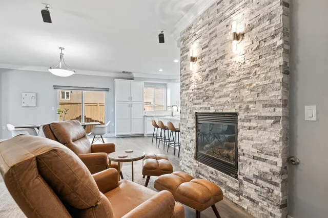 a living room with furniture a fireplace and a chandelier
