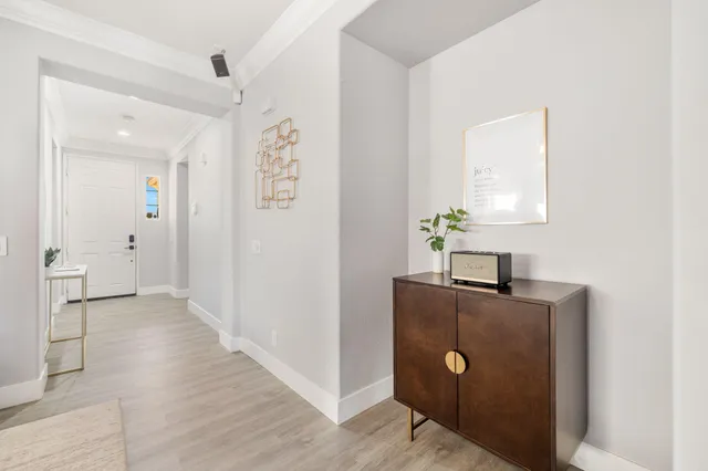 a view of a hallway with wooden floor and cabinet