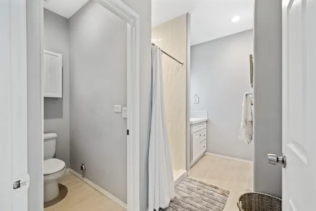 a bathroom with a granite countertop toilet a sink and a mirror