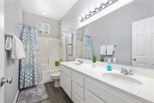 a bathroom with a double vanity sink mirror and toilet