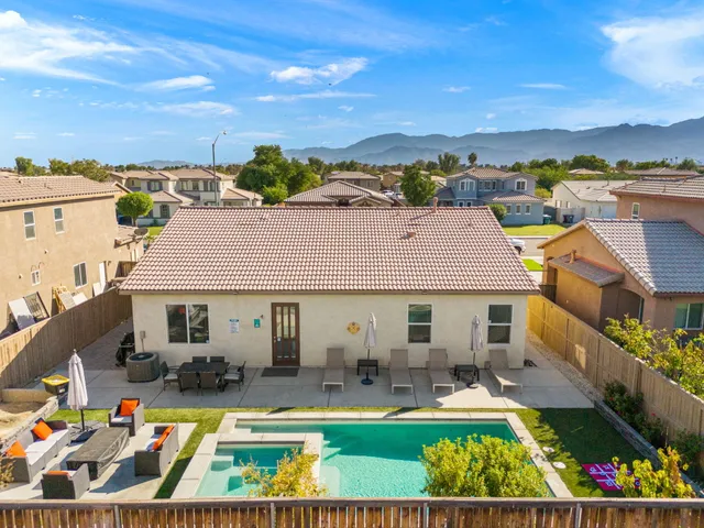 an aerial view of a house with swimming pool garden and patio