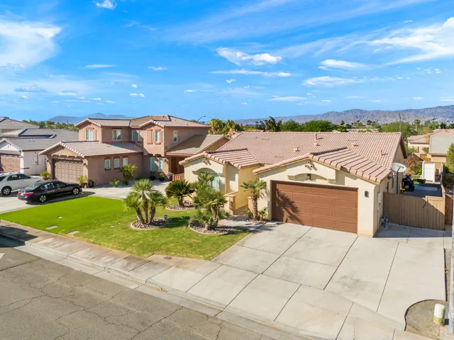 a view of a white house with a big yard and large trees