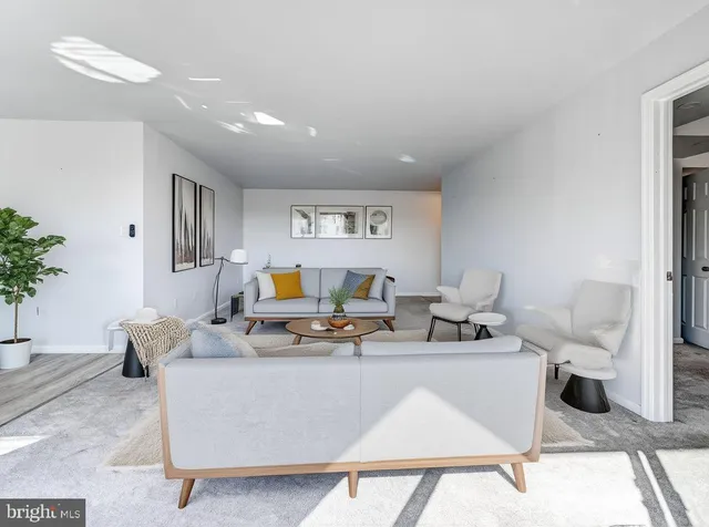 a living room with furniture a table and a potted plant