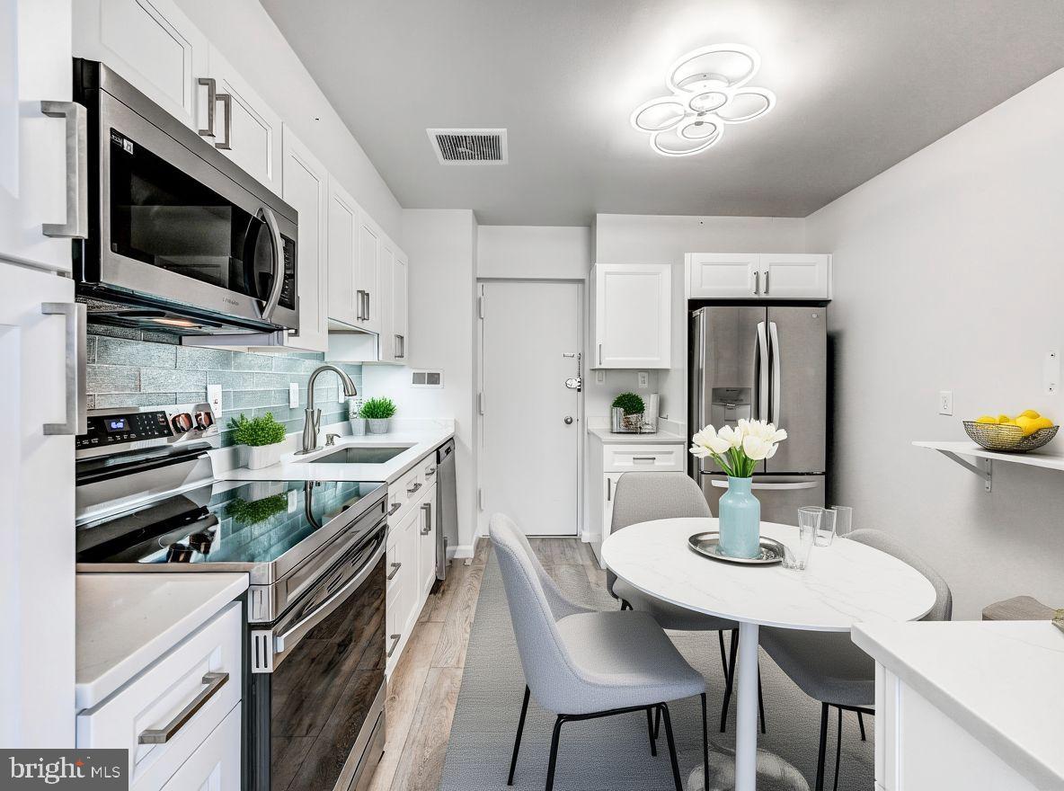 7 Slade Avenue, Unit 718 Pikesville, MD 21208 - Photo 3 of 58 a kitchen with stainless steel appliances granite countertop a sink a stove a microwave a refrigerator and chairs