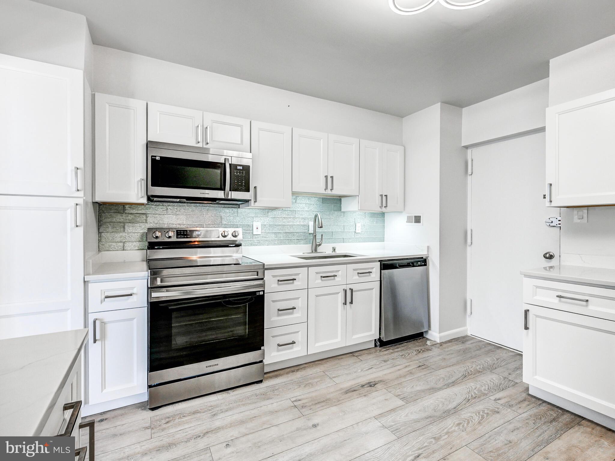 7 Slade Avenue, Unit 718 Pikesville, MD 21208 - Photo 4 of 58 a kitchen with granite countertop a stove a microwave a sink and cabinets