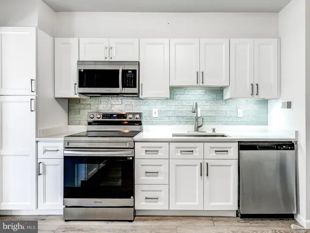 a kitchen with stainless steel appliances granite countertop a stove and a microwave