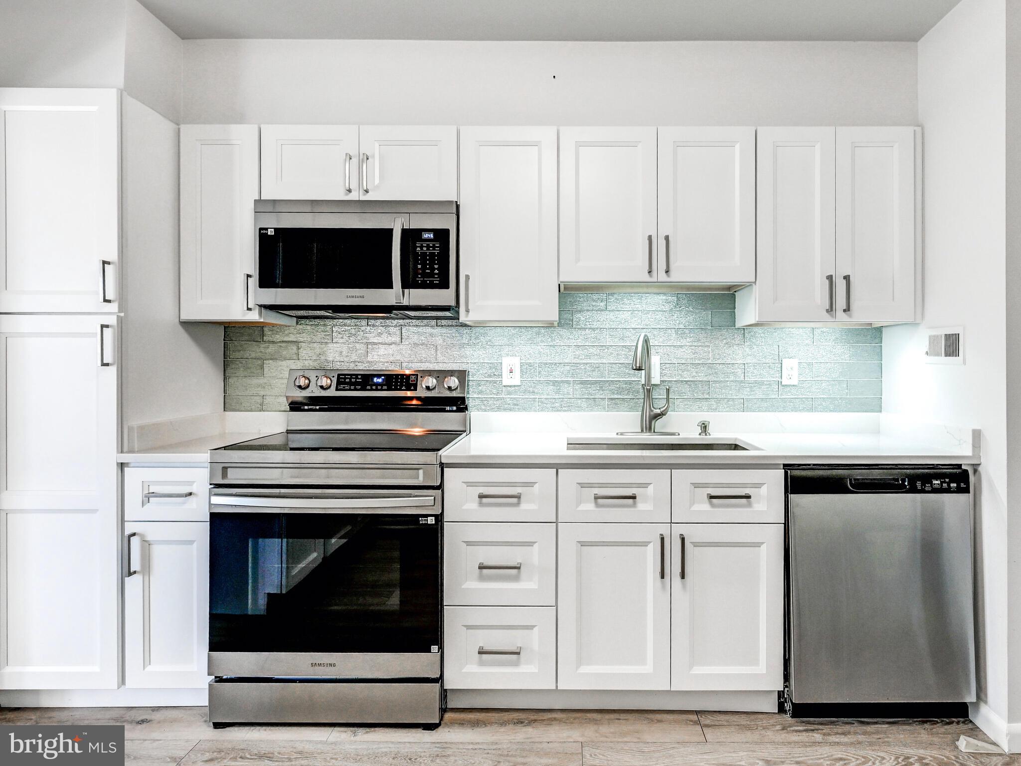 7 Slade Avenue, Unit 718 Pikesville, MD 21208 - Photo 5 of 58 a kitchen with stainless steel appliances granite countertop a stove and a microwave