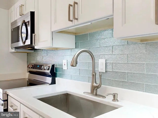 a kitchen with a sink and a stove top oven