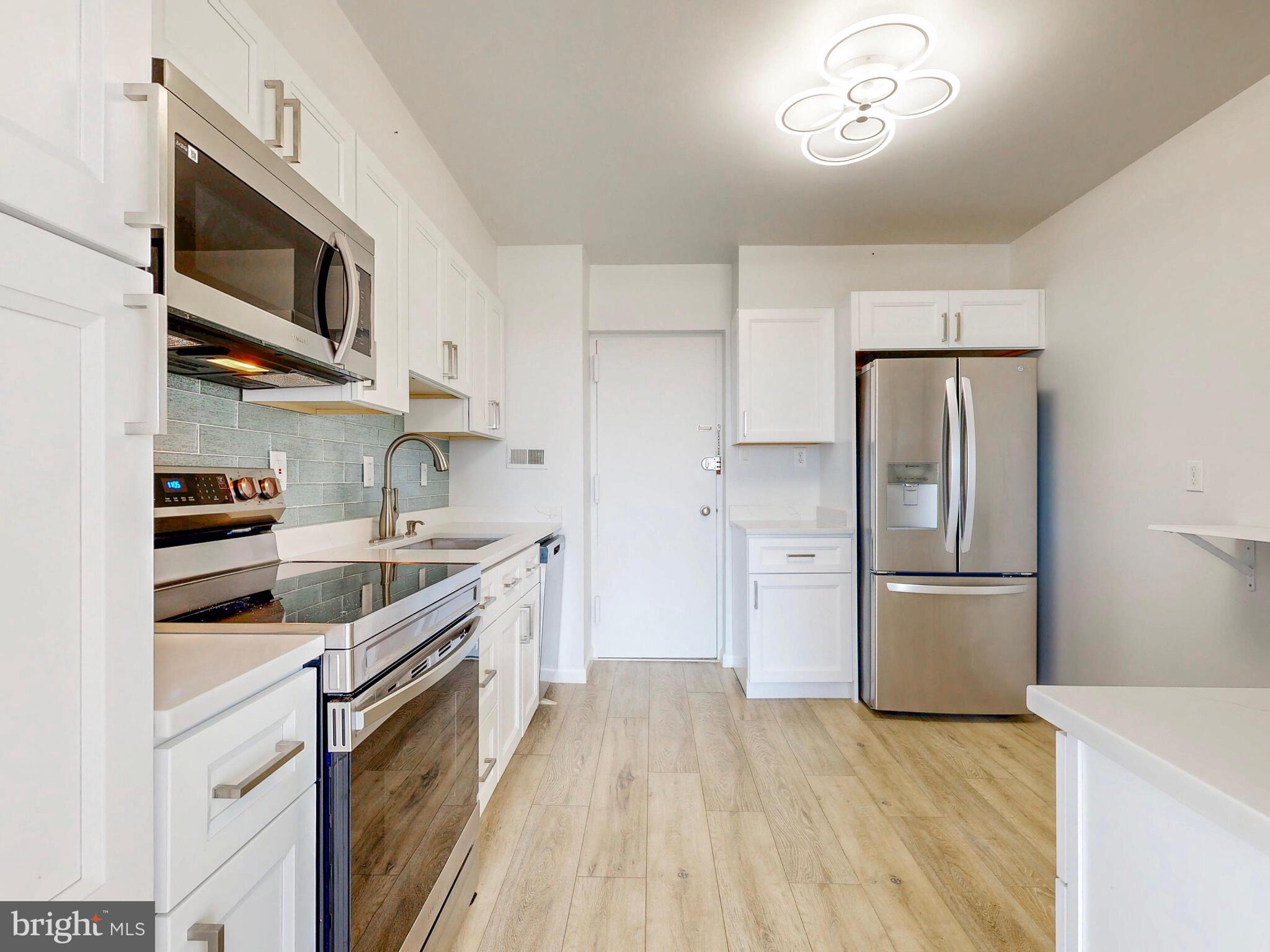 7 Slade Avenue, Unit 718 Pikesville, MD 21208 - Photo 9 of 58 a kitchen with stainless steel appliances a refrigerator stove and microwave