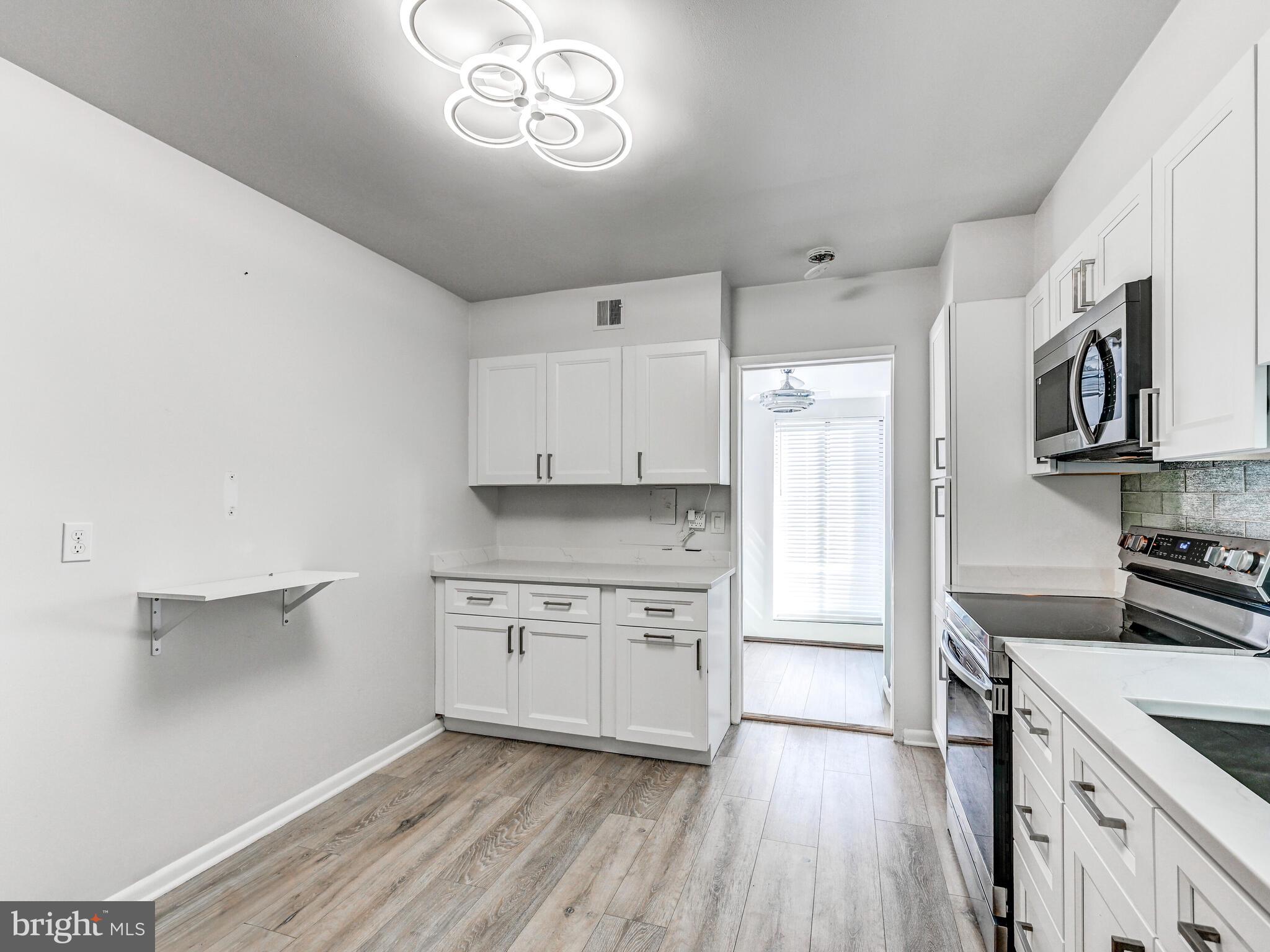 7 Slade Avenue, Unit 718 Pikesville, MD 21208 - Photo 10 of 58 a kitchen with stainless steel appliances granite countertop a stove and a refrigerator