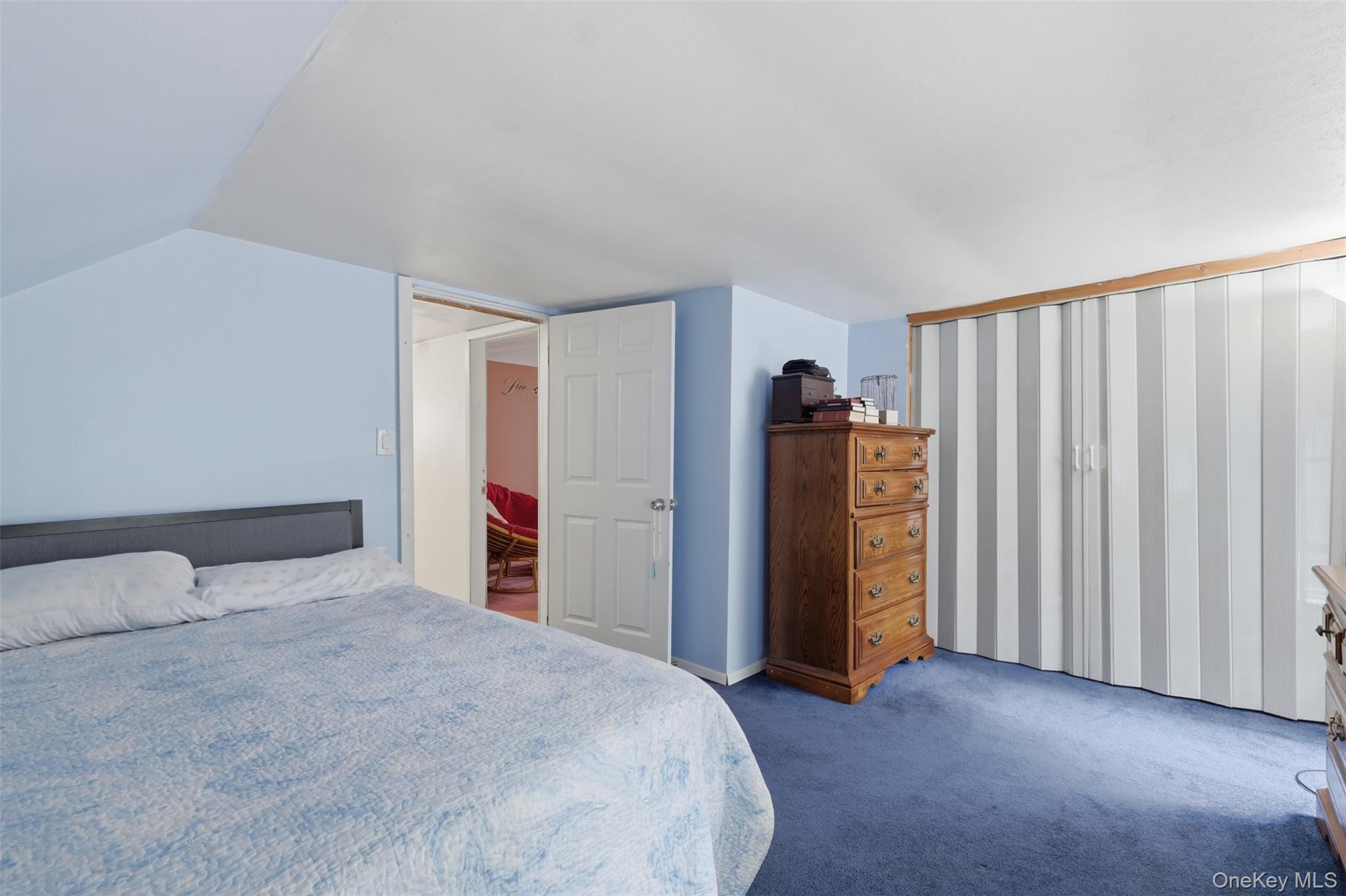 236 Hosner Mountain Road Hopewell Junction, NY 12533 - Photo 35 of 46 Upstairs bedroom #1 with blue wall paint complementing blue carpeting, with a white accordion closet door system