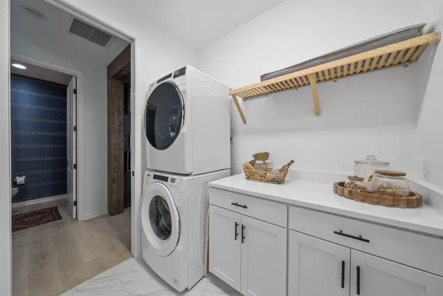 a bedroom with a bed table chair and flat screen tv