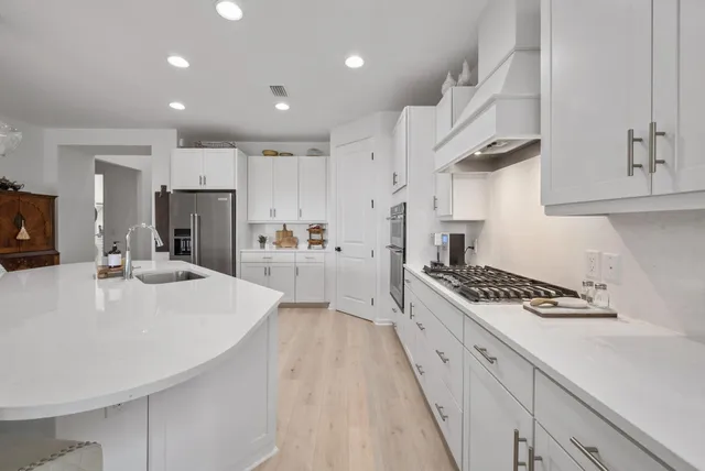 a living room with furniture a fireplace and a dining table with wooden floor