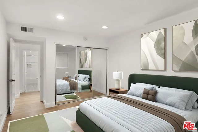 a bedroom with a bed and wooden floor