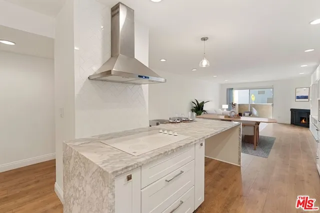 a kitchen with a stove a refrigerator a sink dishwasher with a dining table and chairs with wooden floor