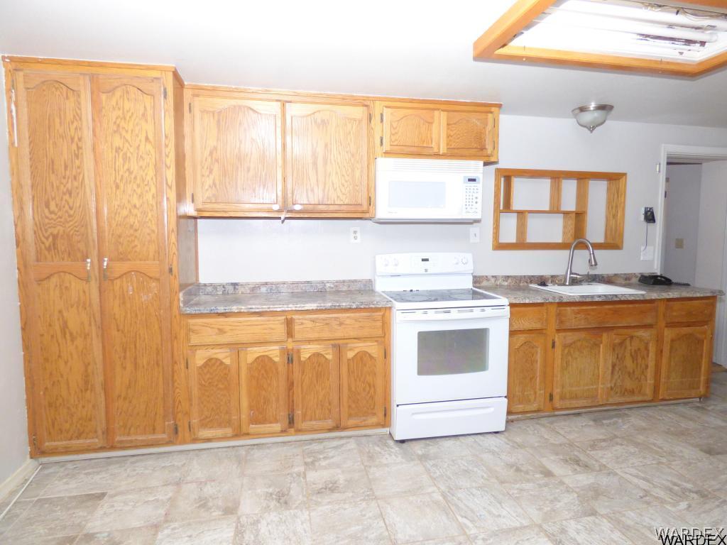 3715 Bosque Road Golden Valley, AZ 86413 - Photo 14 of 36 a kitchen with stainless steel appliances granite countertop a stove a sink and a refrigerator