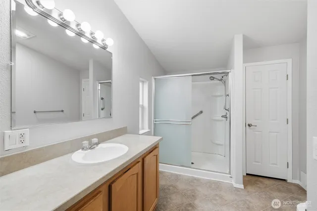 a bathroom with a sink shower and a mirror