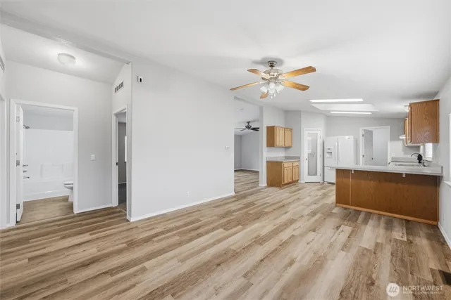 a view of a kitchen with wooden floor and a ceiling fan