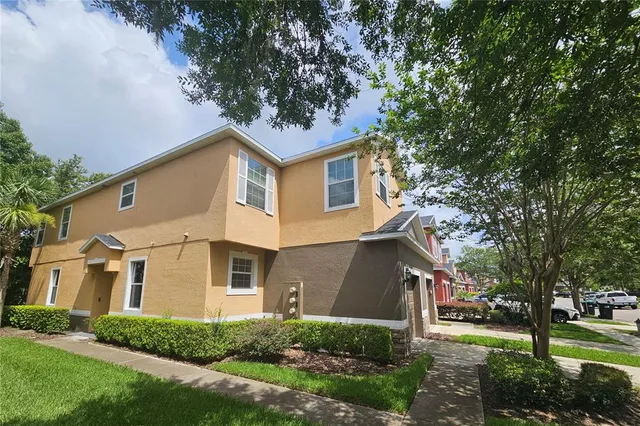 a front view of a house with a yard and trees