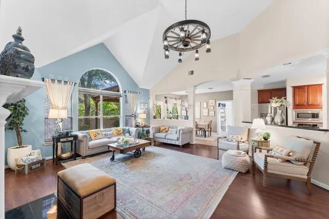 a living room with furniture chandelier and a large window