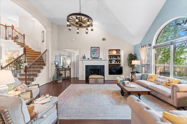 a living room with furniture a fireplace and a large window