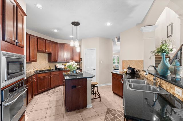 a kitchen with a sink stainless steel appliances and cabinets