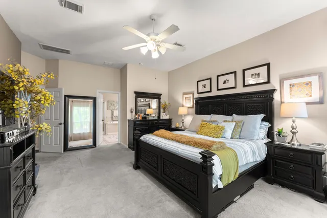 a spacious bedroom with a bed and a chandelier