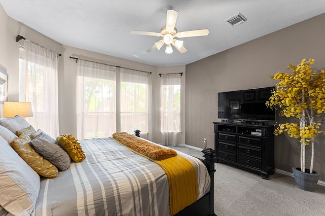 a bedroom with a bed and a flat tv screen on dresser