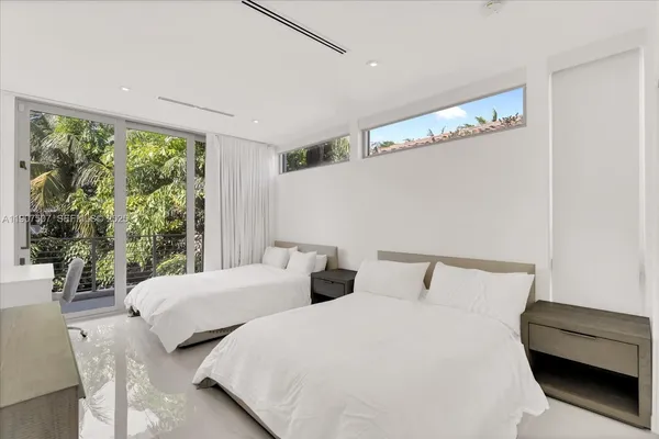 a bedroom with two beds and a large window