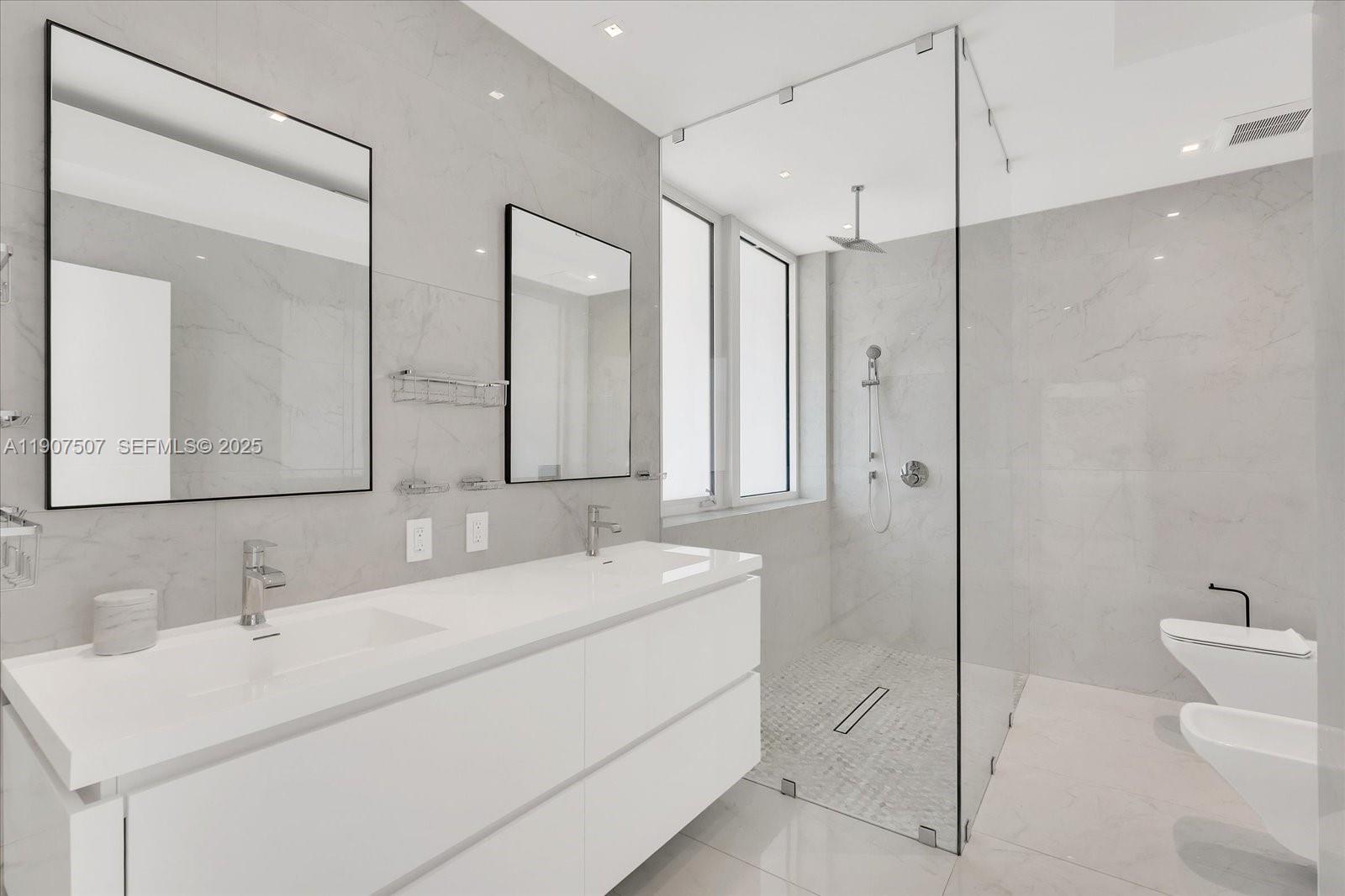 7830 Atlantic Way Miami Beach, FL 33141 - Photo 20 of 34 a bathroom with a double vanity sink mirror and toilet