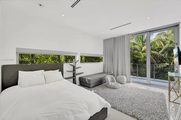 a bedroom with large bed and a large window