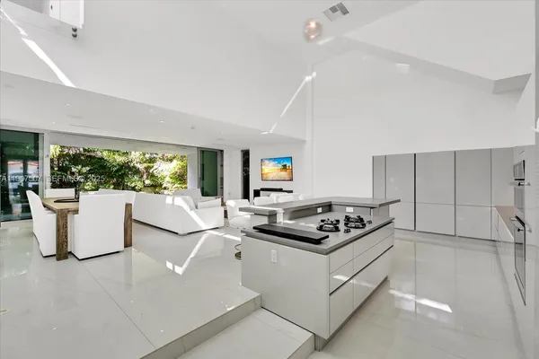 a kitchen with a counter top space a sink a refrigerator a window and a couch