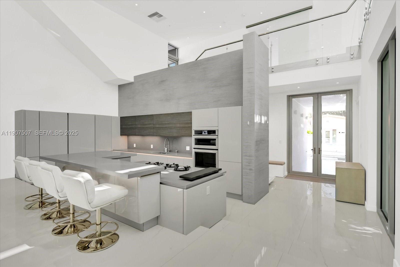 7830 Atlantic Way Miami Beach, FL 33141 - Photo 6 of 34 a kitchen with stainless steel appliances a sink stove and cabinets