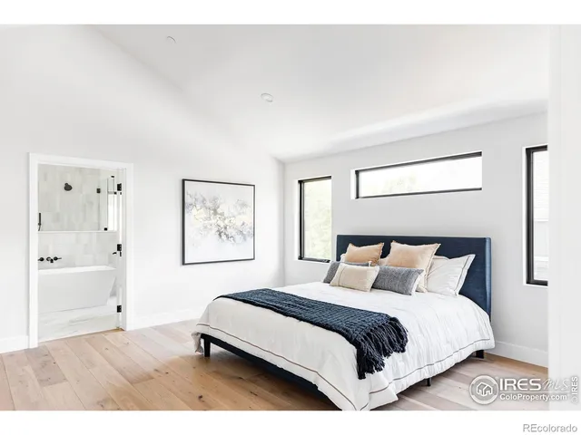 a bedroom with a bed and painting on the wall