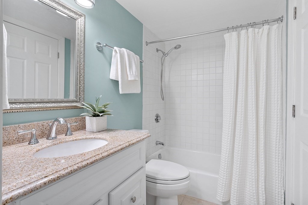 25 Holly Lane, Unit 2A Brookline, MA 02467 - Photo 12 of 34 a bathroom with a granite countertop sink and a mirror
