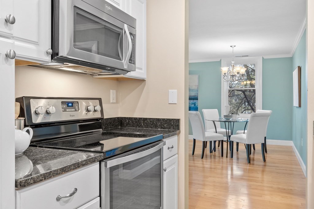 25 Holly Lane, Unit 2A Brookline, MA 02467 - Photo 15 of 34 a kitchen with a stove cabinets and dining table