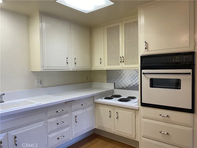 a kitchen with granite countertop white cabinets and white appliances