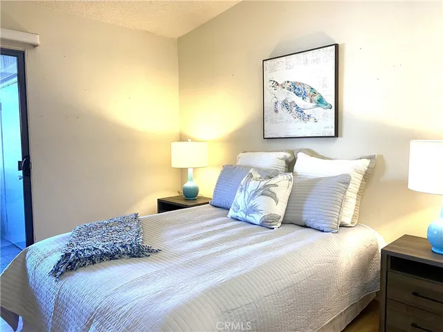 a bedroom with a bed and painting on the wall