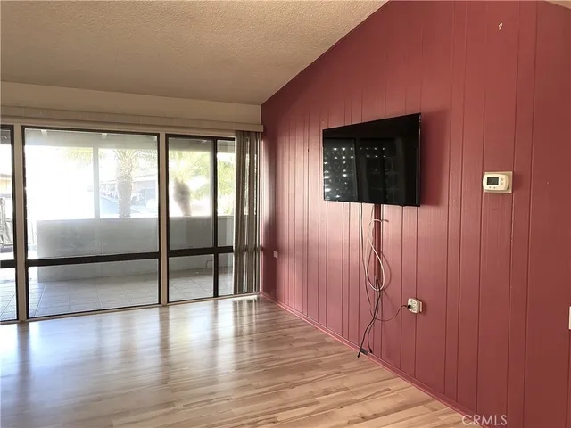 a view of a hallway with wooden floor and windows