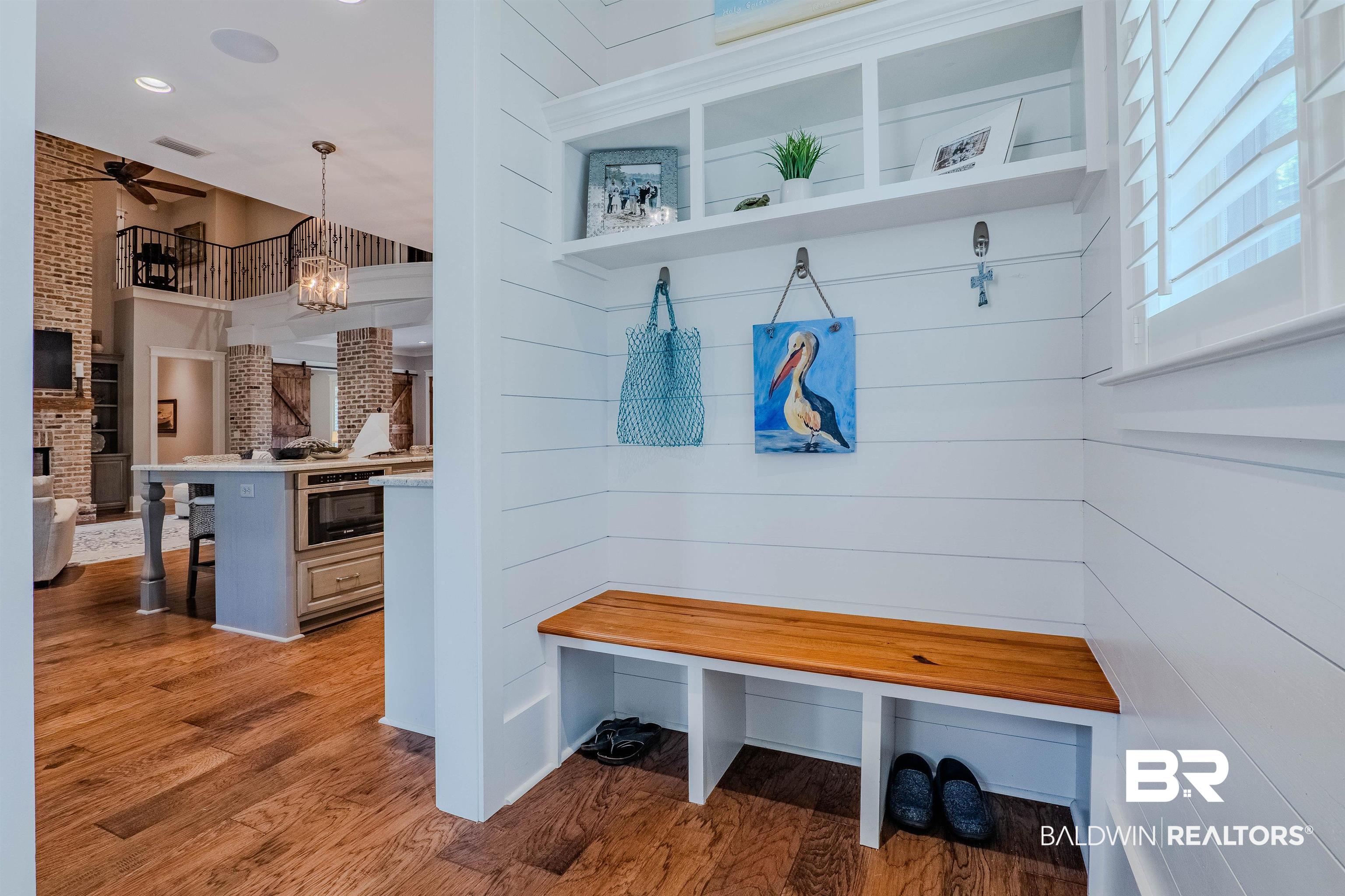 708 Manning Place Fairhope, AL 36532 - Photo 41 of 58 Mudroom featuring a fireplace, ceiling fan with notable chandelier, light hardwood / wood-style flooring, and brick wall