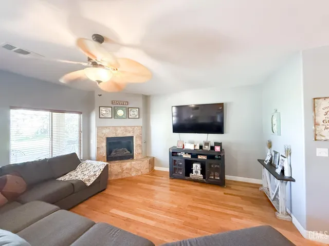 a living room with furniture a fireplace and a flat screen tv