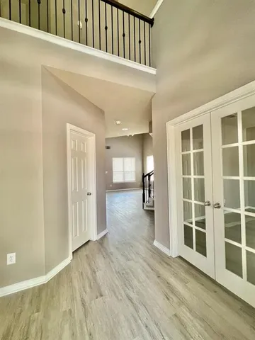 a view of empty room with wooden floor and windows