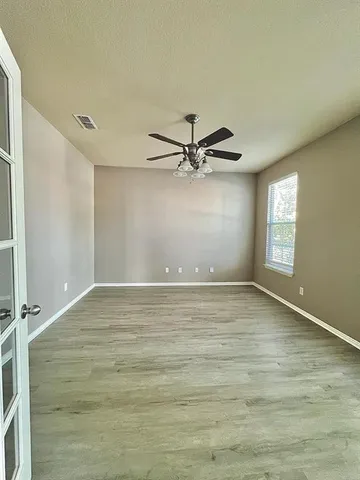 a view of a room with window and ceiling fan