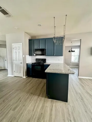 a kitchen with kitchen island a refrigerator sink and stove